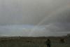 Rainbow in the horizon, treasure hunter on the beach.
