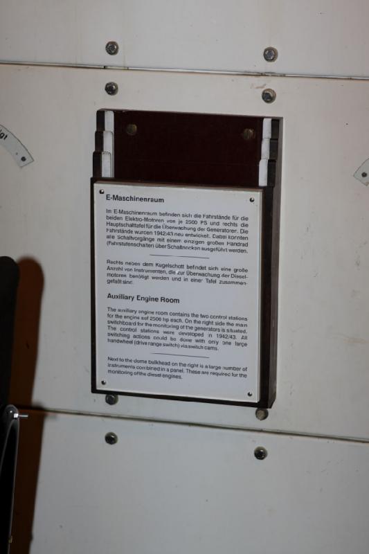 2010-04-15 15:55:20 ** Bremerhaven, Germany, Submarines, Type XXI, U 2540 ** Auxiliary Engine Room

The auxiliary engine room contains the two control stations for the engines of 2500 hp each. On the right side the main switchboard for the monitoring of the generators is situated. The control stations were developed in 1942/43. All switching actions could be done with only one large handwheel (drive range switch) via switch cams.

Next to the dome bulkhead on the right is a large number of instruments combined in a panel. These are required for the monitoring of the diesel engines.