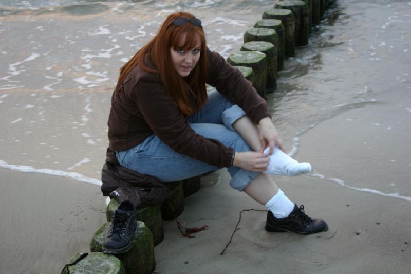 2006-11-26 15:56:28 ** Deutschland, Katie, Warnemünde ** Katie zieht sich Socken und Schuhe an, nachdem sie sich gegen ein Bad in der Ostsee entschieden hat.